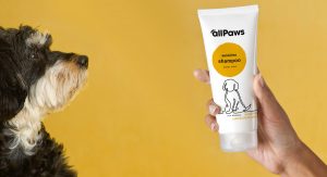 Dog Looking at All Paws Shampoo Tube in Hand