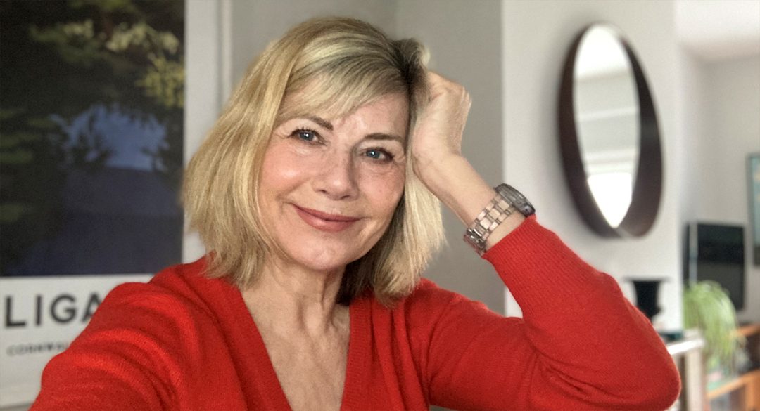 Glynis pose wearing red jumper