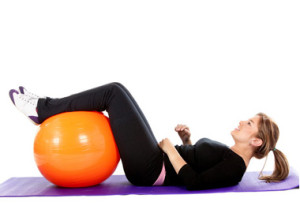Girl on an excercise matt with a swiss ball